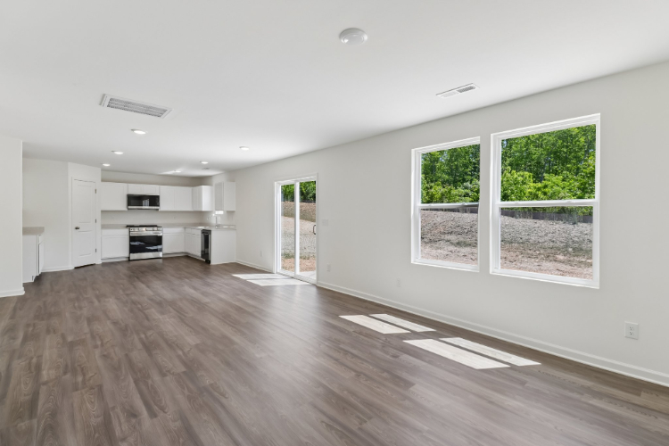 A large empty room with a wood floor and a wood floor.
