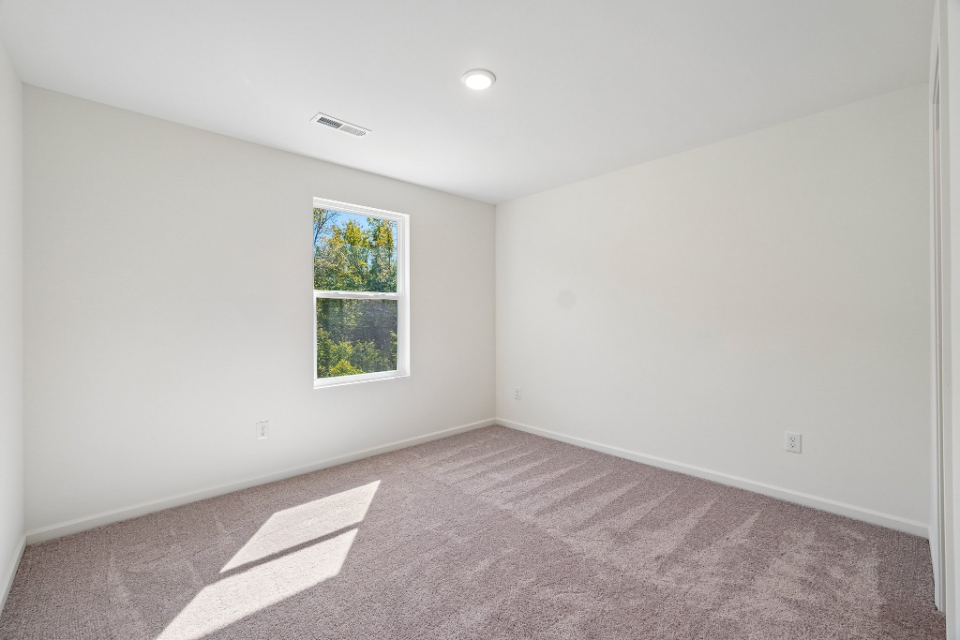 A room with a window and carpet.