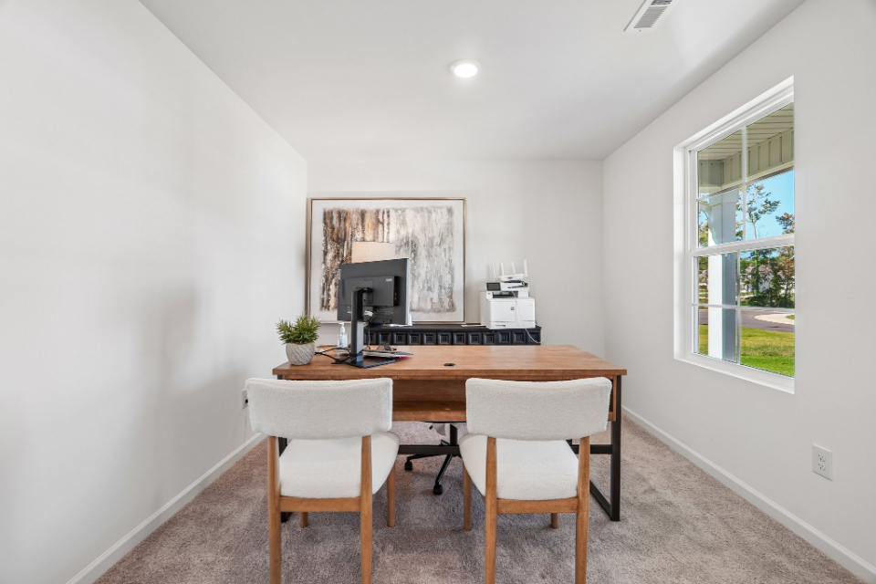 A dining room with a table and chairs.