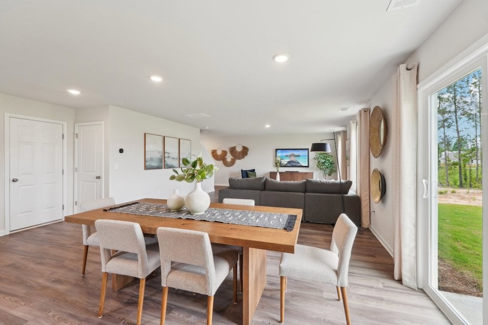 A living room with a large table and chairs.