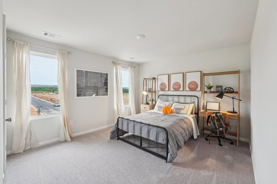 A bedroom with a bed and a chair.