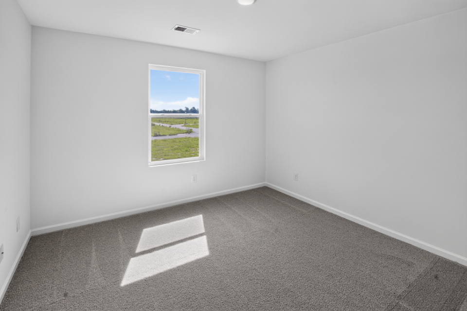 A room with a window and a rug.