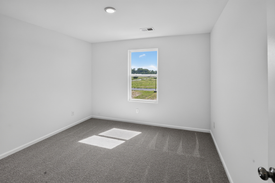 A room with a window and a rug.