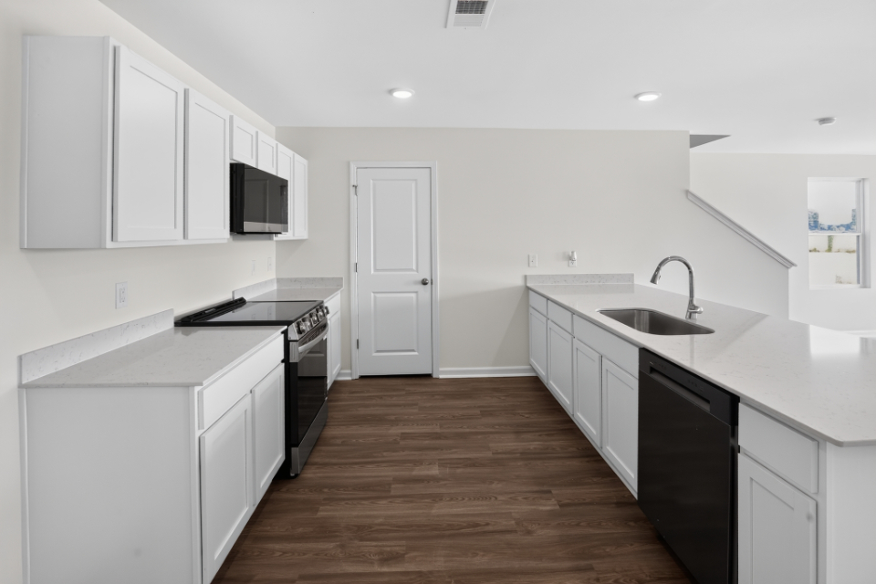 A kitchen with white cabinets.