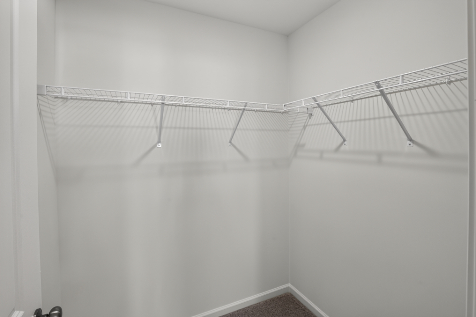 A white wall with a metal bar.