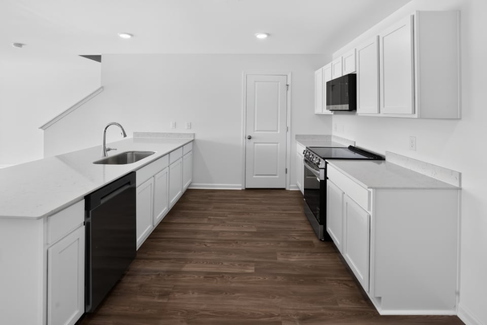 A kitchen with white cabinets.