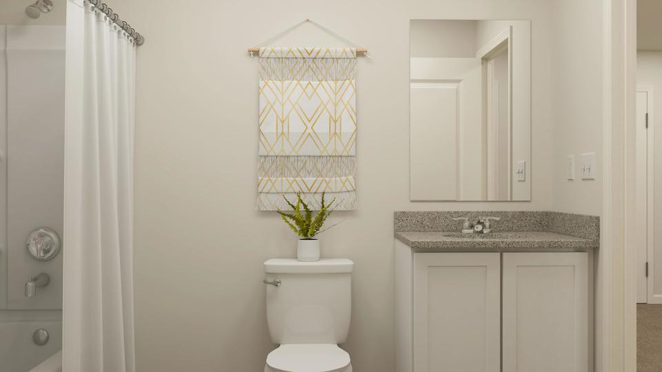 A bathroom with a plant on the toilet.