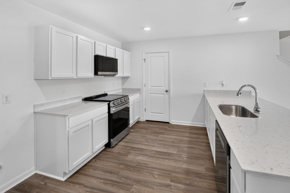 A kitchen with white cabinets.