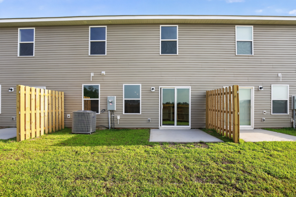 A house with a fence and grass.