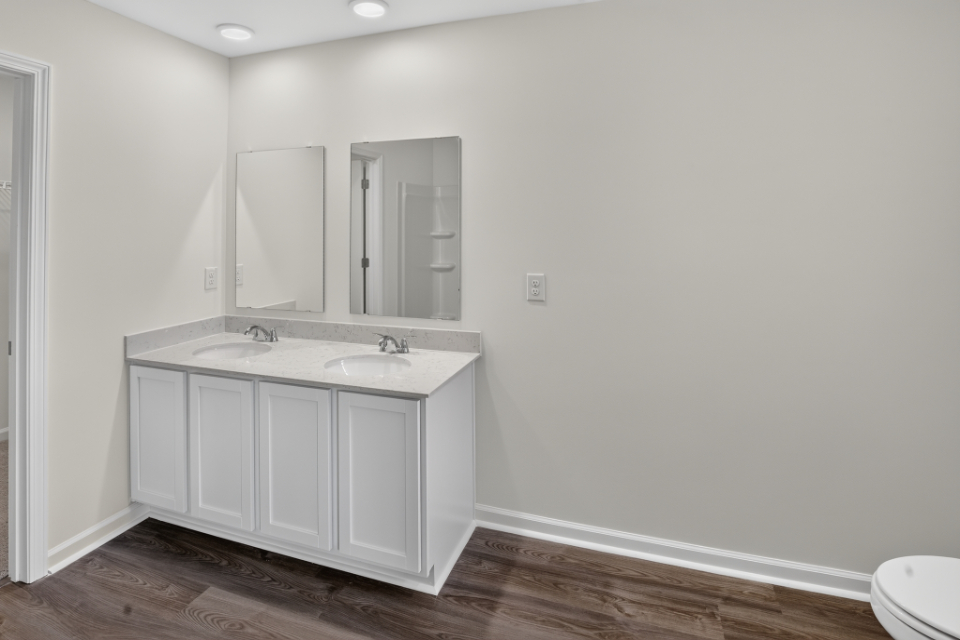 A bathroom with white cabinets.