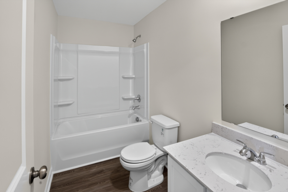 A bathroom with a toilet sink and bathtub.