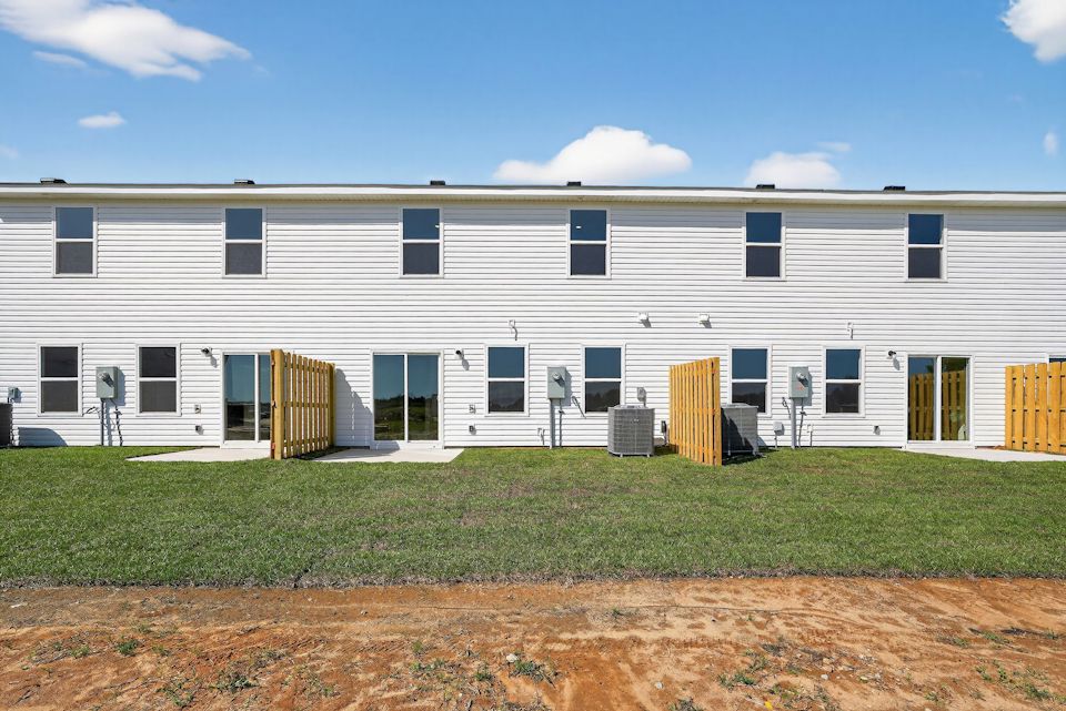 A white building with a lawn in front of it.