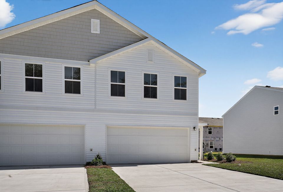 A white house with garages.