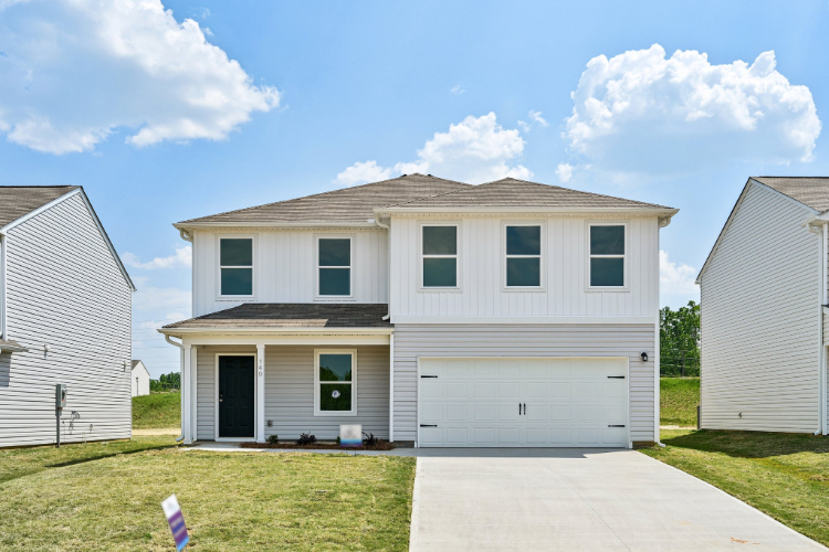 A house with garages and grass.