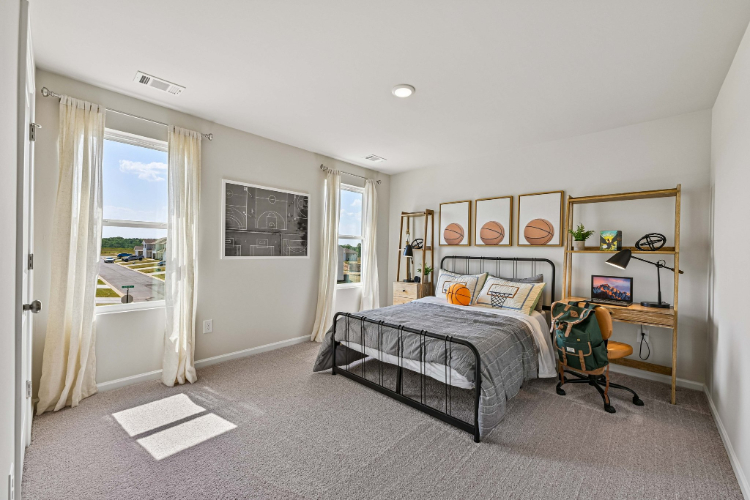 A bedroom with a bed and a chair.