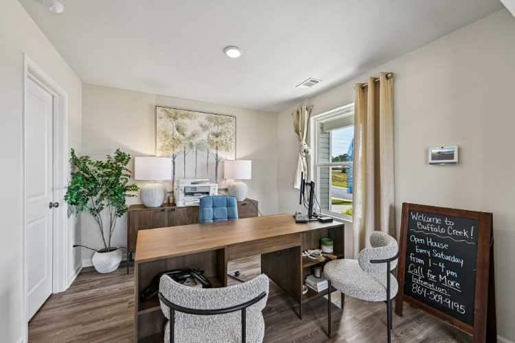 A room with a desk and chairs.