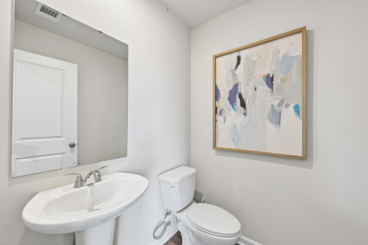 A bathroom with a painting on the wall.