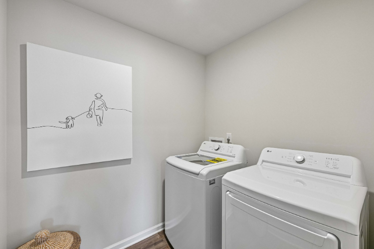 A laundry room with a white wall.