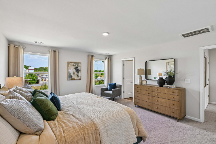 A bedroom with a bed and a chair.