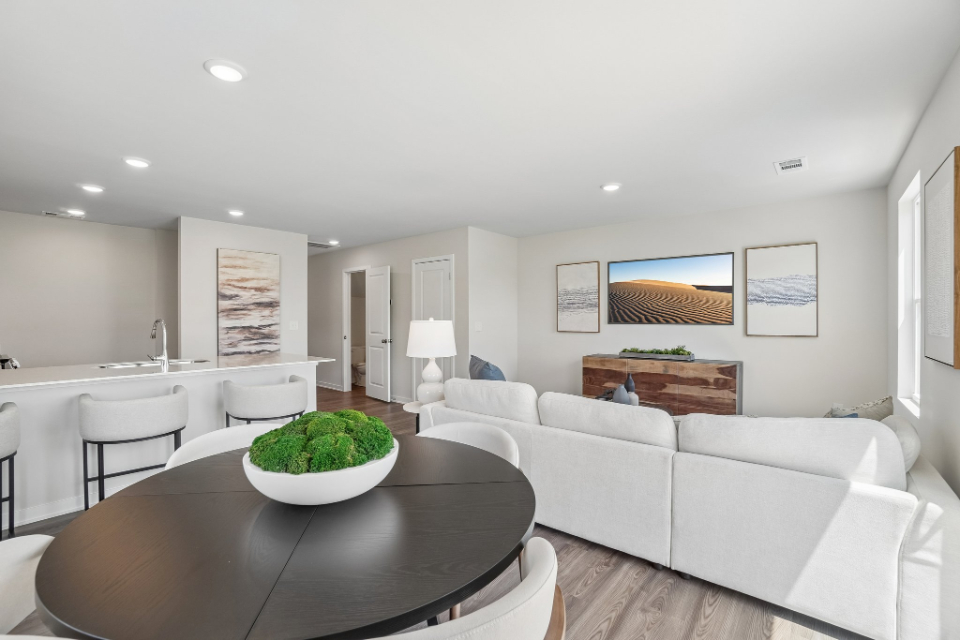 A living room with a large white couch and a round table.