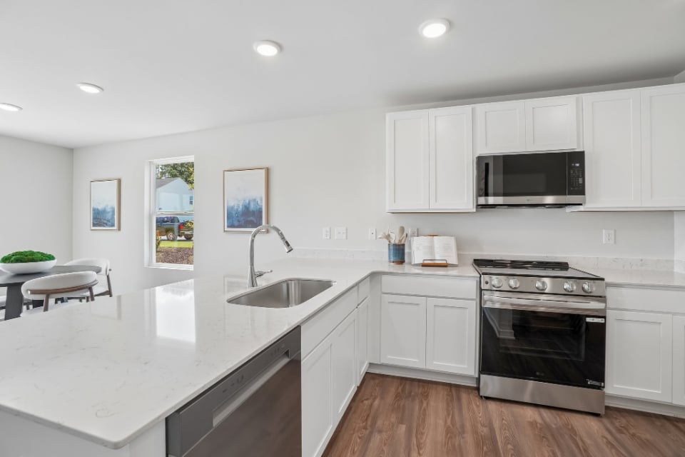 A kitchen with white cabinets.