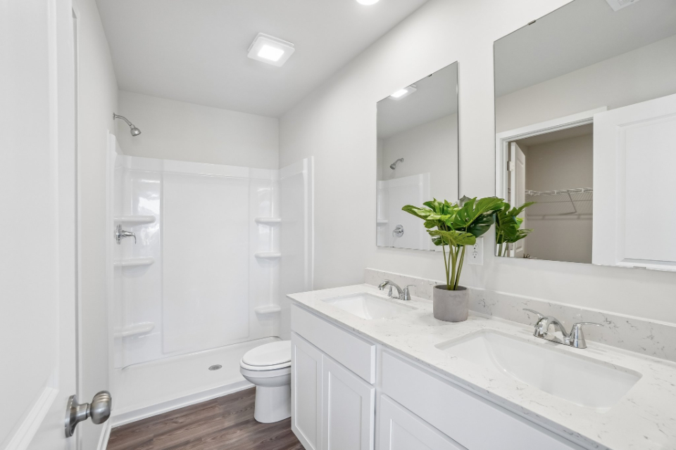 A bathroom with a sink toilet and a mirror.