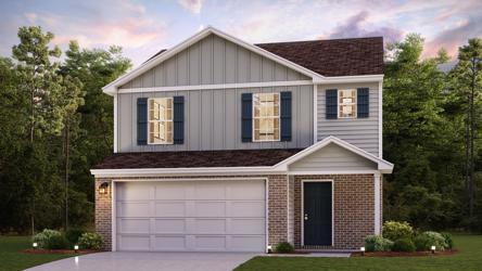 A house with a garage and trees in the back.