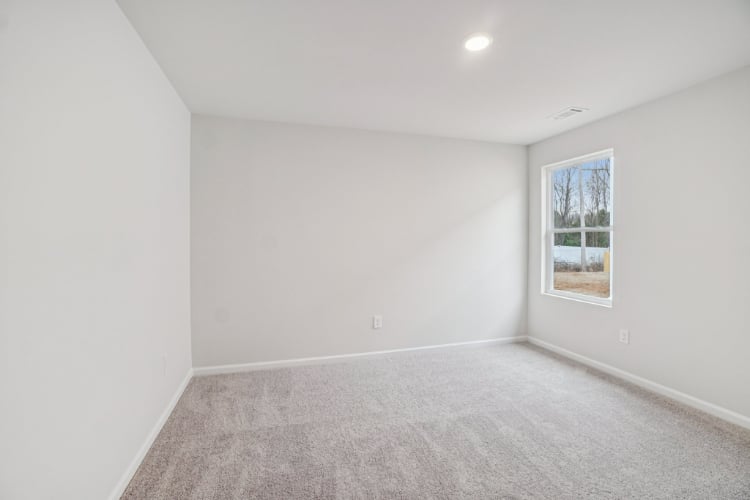 A room with a carpet and a window.