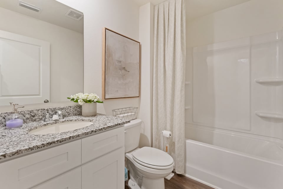 A bathroom with a tub sink and toilet.