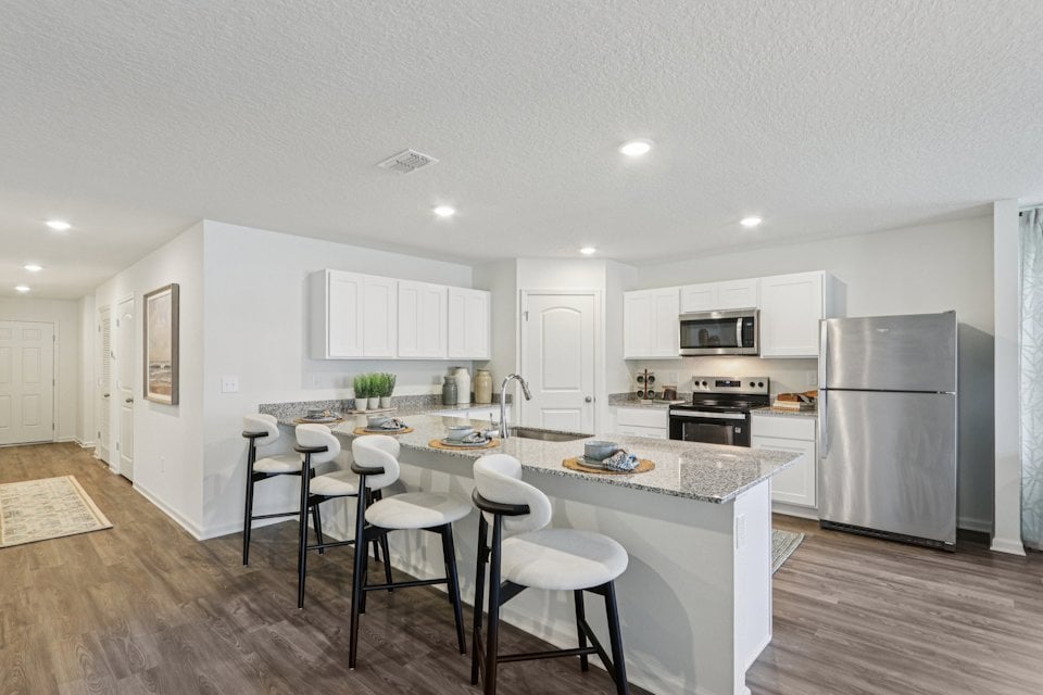 A kitchen with white cabinets.