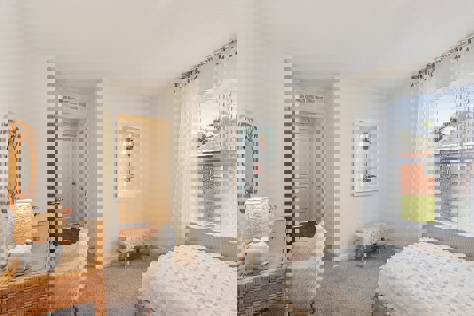 A bedroom with a bed and a chair.