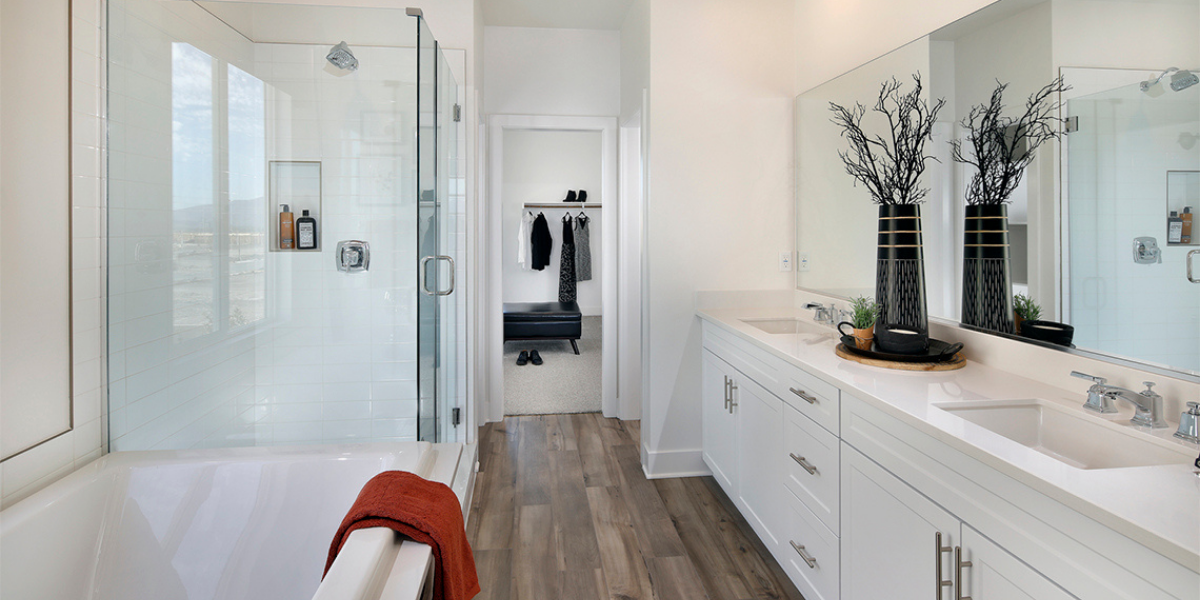 Pristine en-suite bath with dual vanities, standing tub and access to a roomy walk-in closet. 
