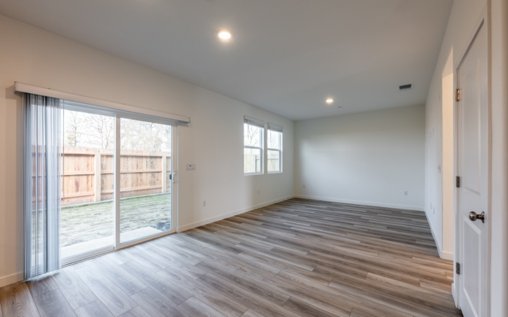 A room with a wood floor and windows.