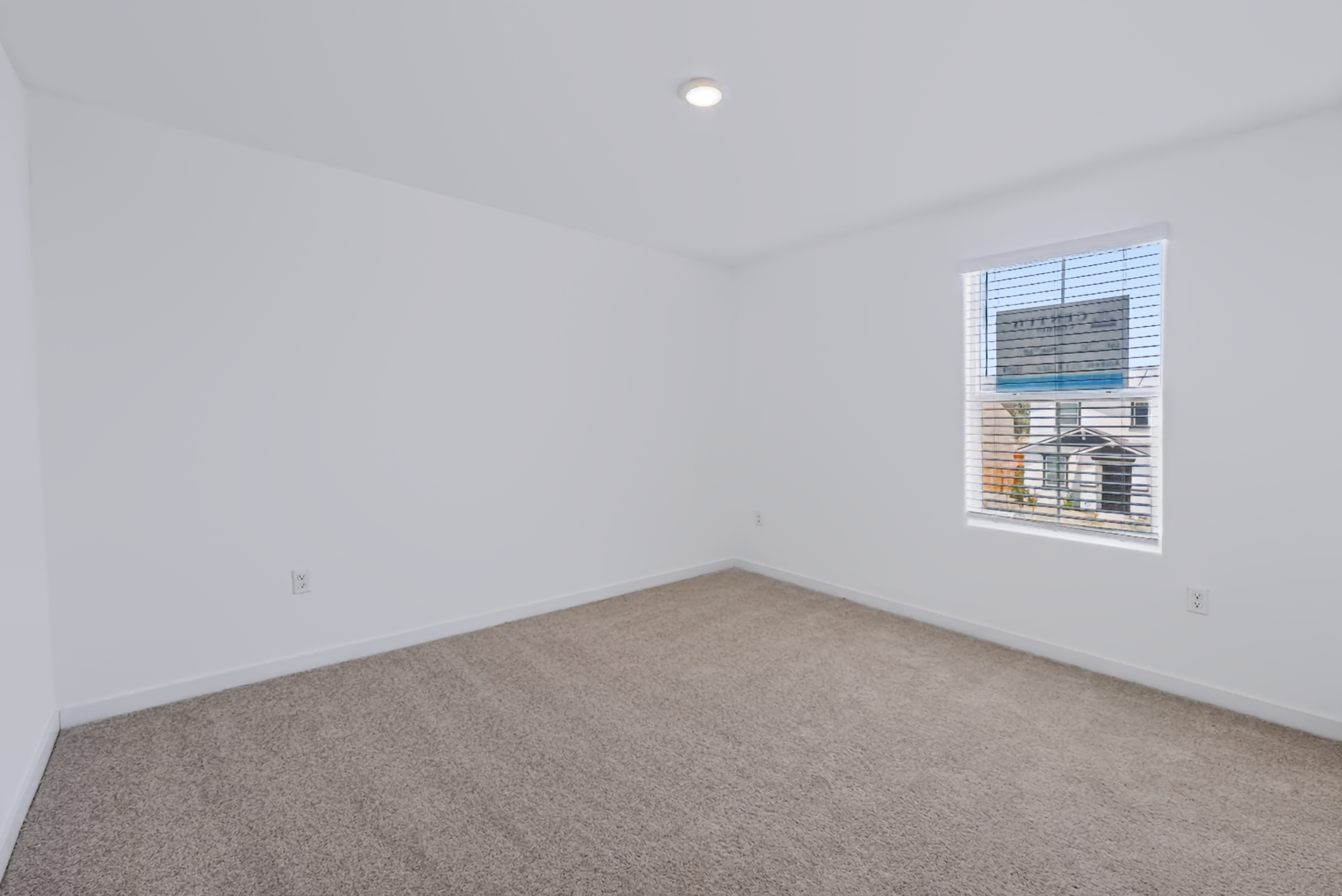 A room with a carpet and a window.