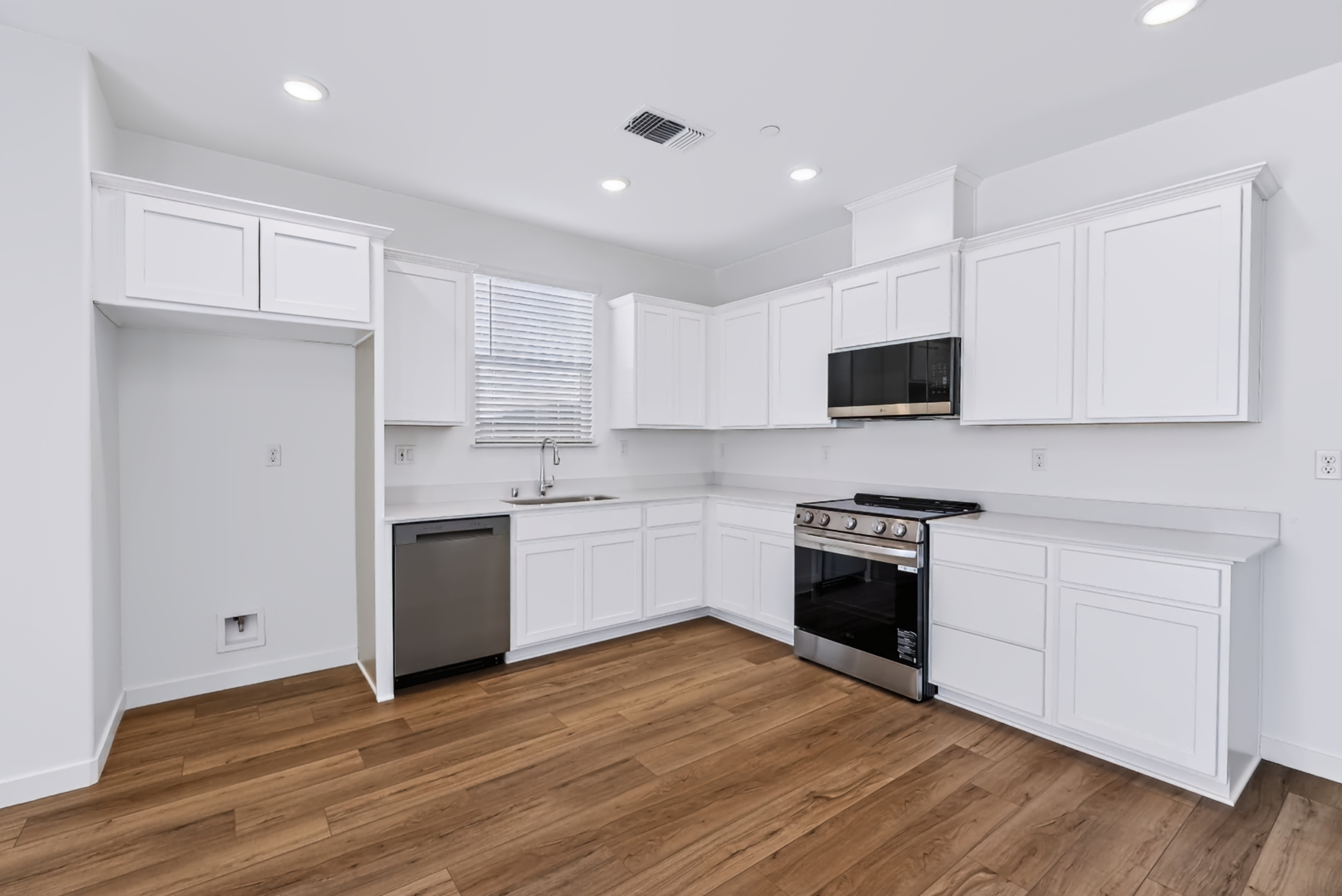 A kitchen with white cabinets.