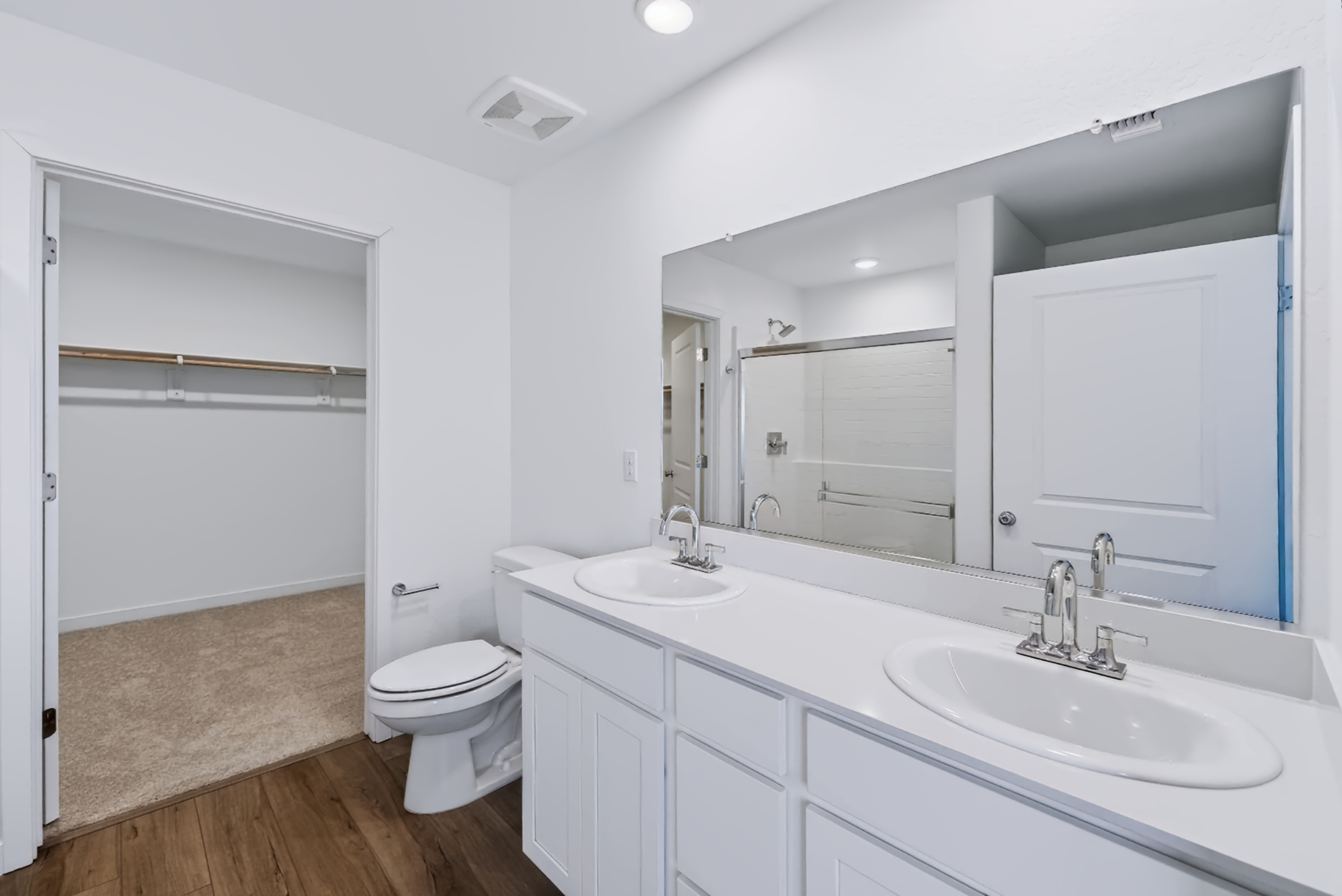 A bathroom with white cabinets.