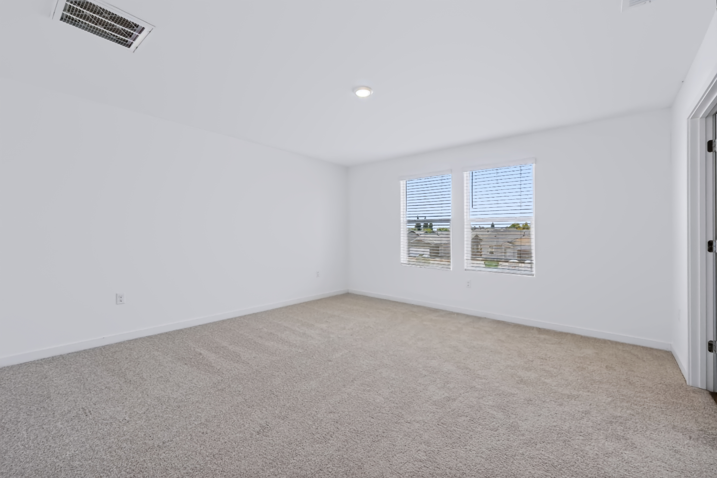 A room with a carpet and a window.