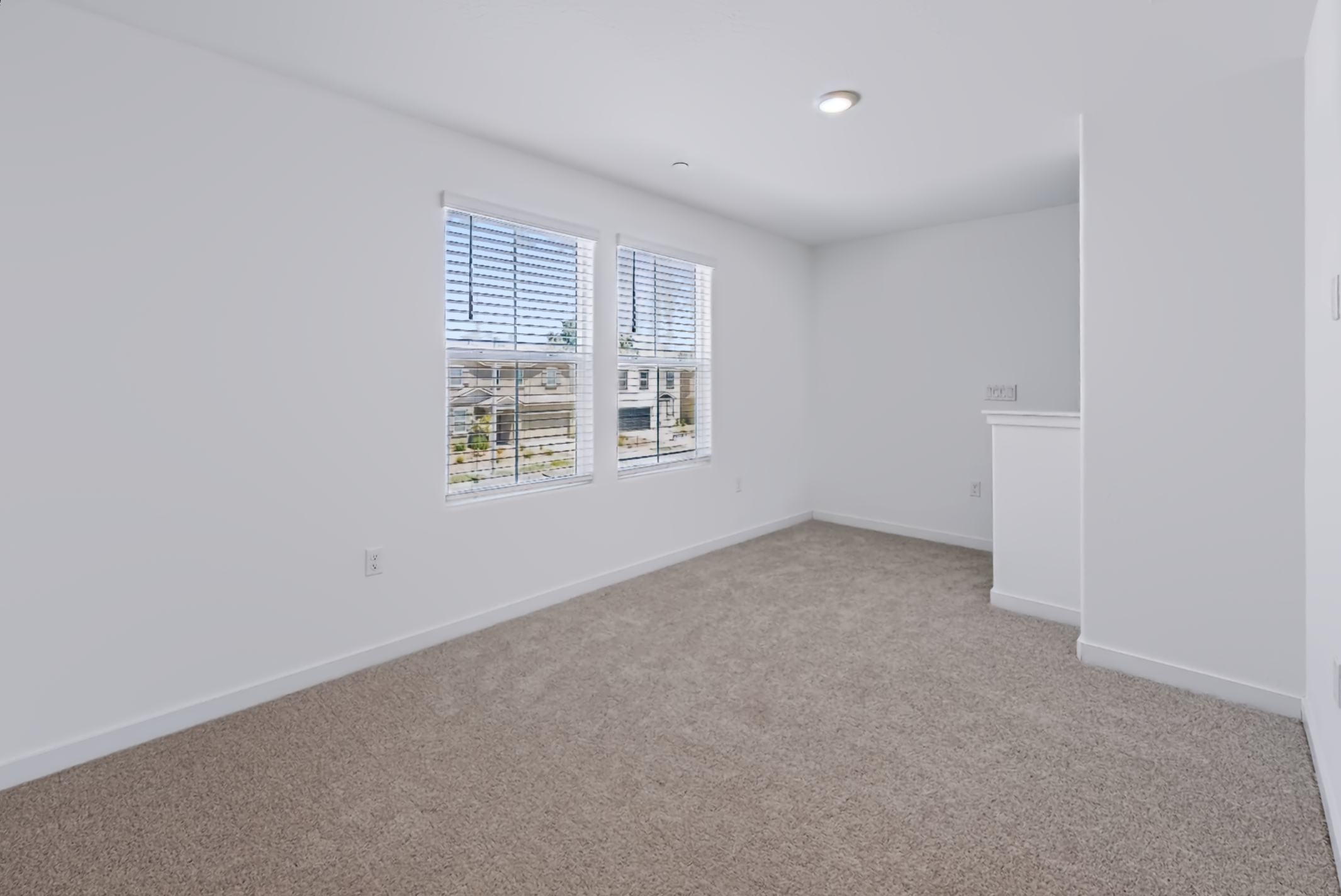 A room with a window and a white wall.