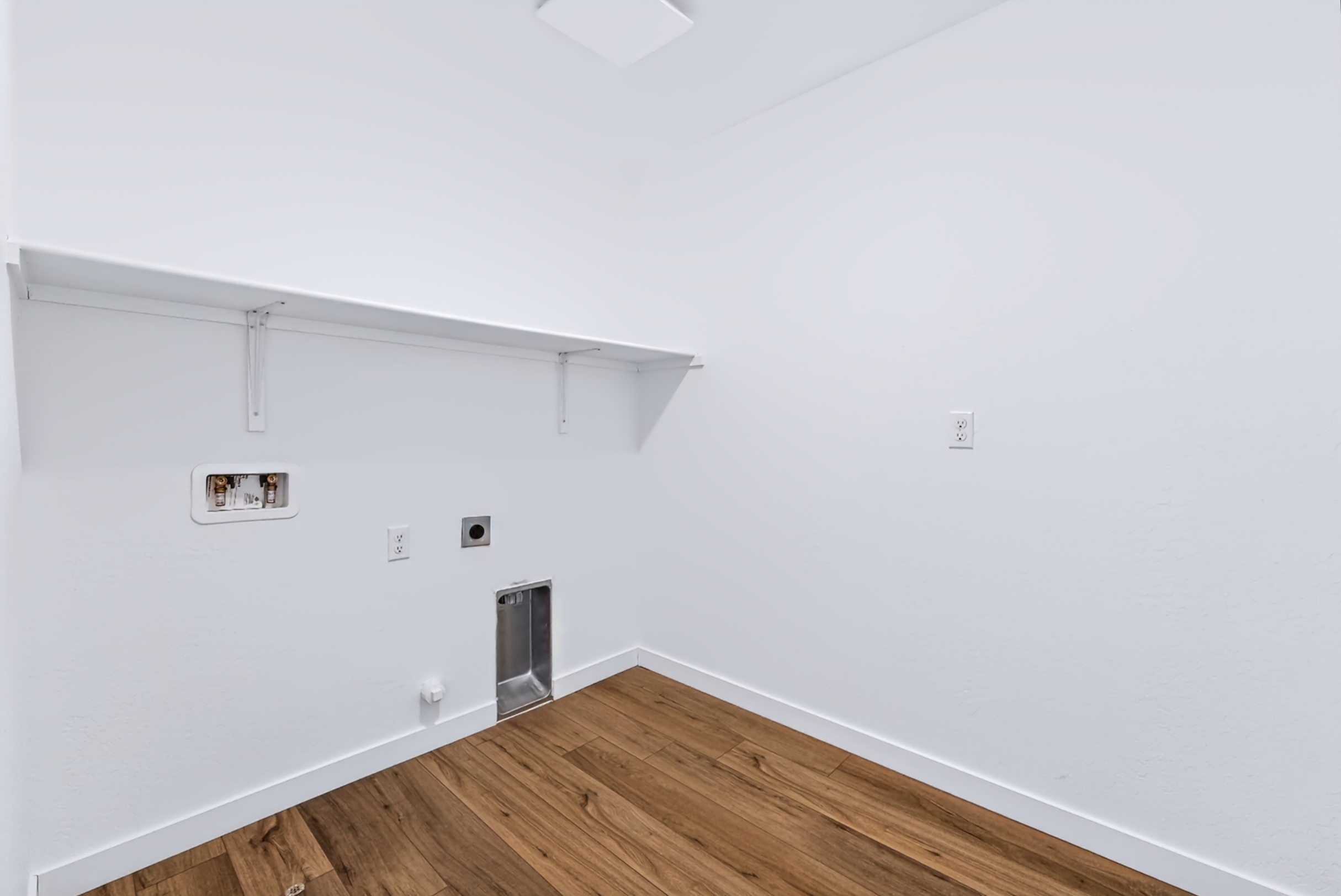 A room with a wood floor and white walls.