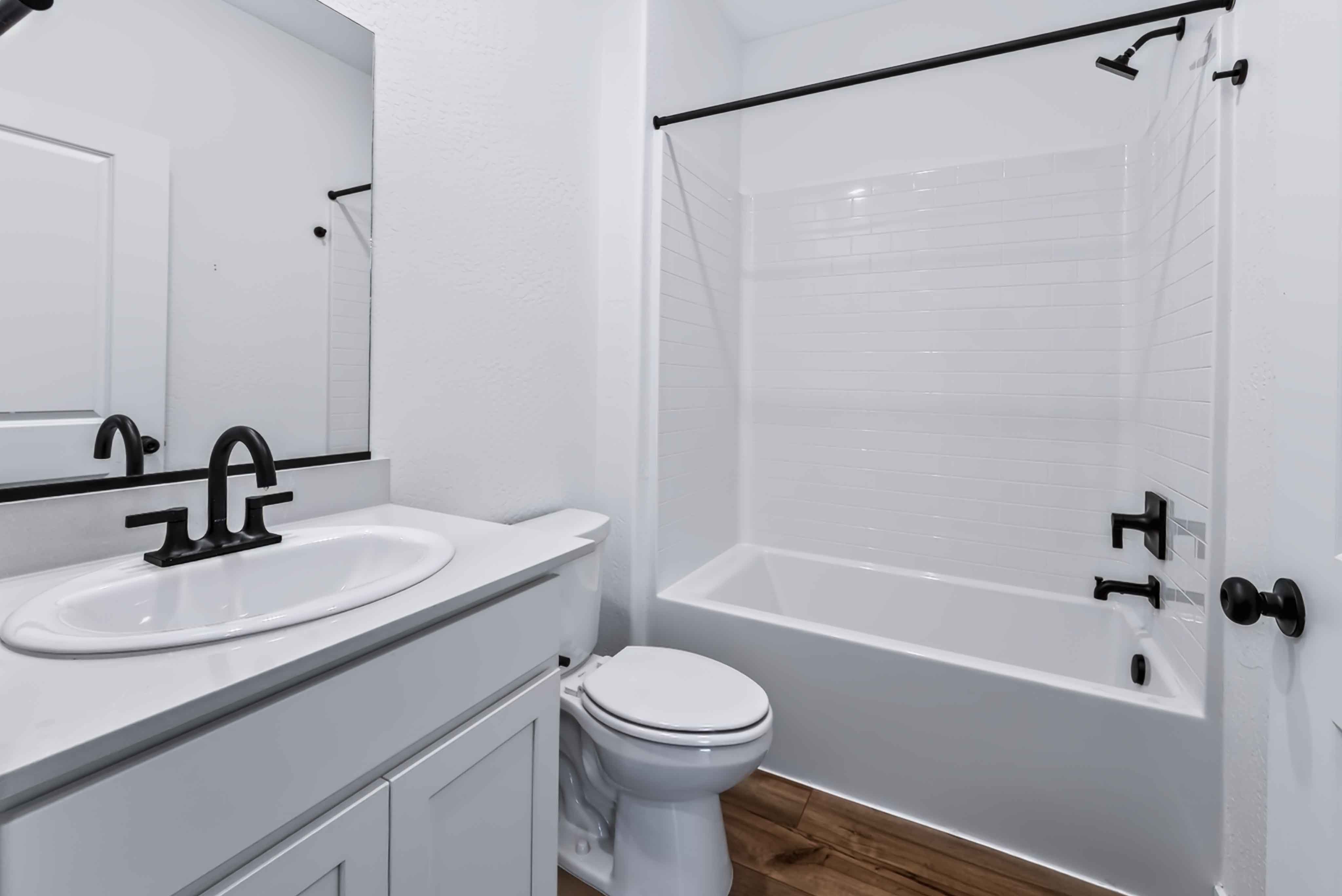 A bathroom with a sink toilet and bathtub.