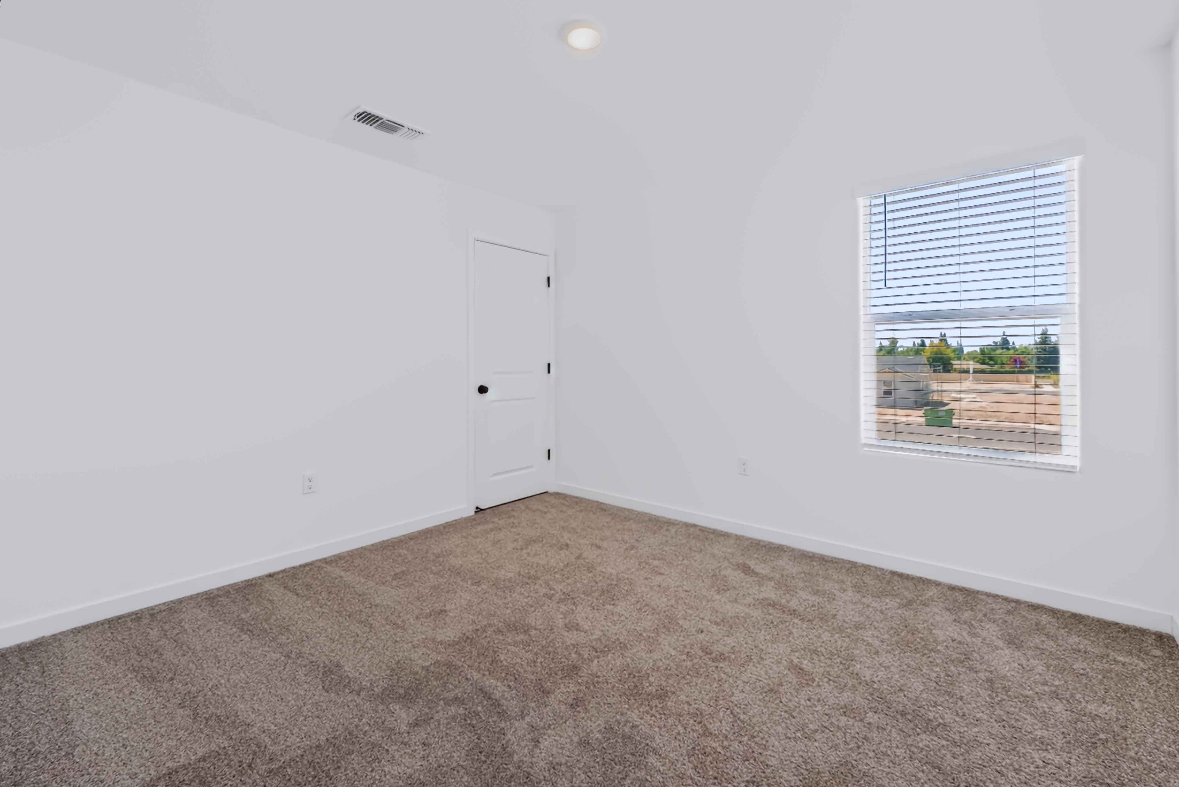A room with a white door and a window.
