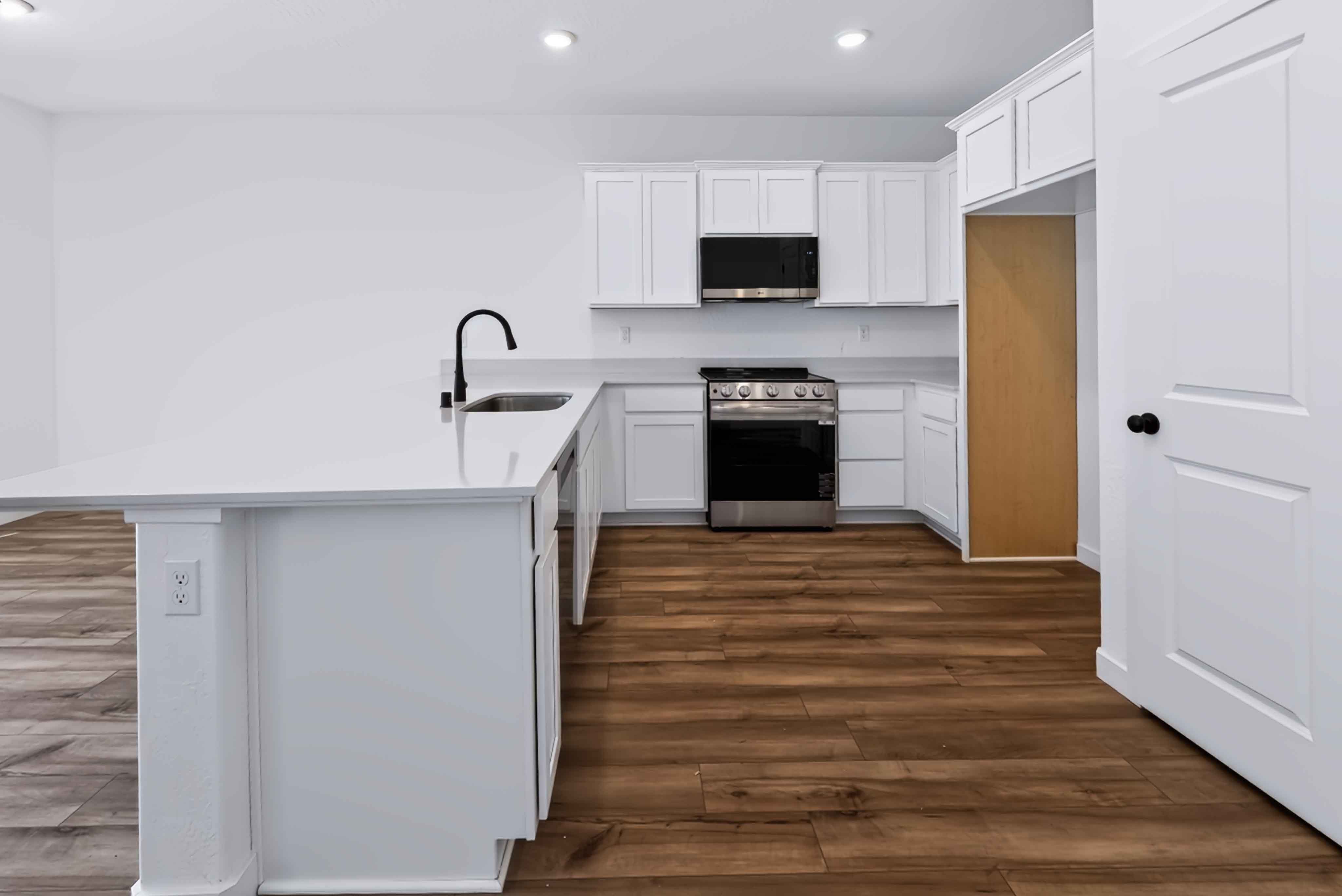 A kitchen with white cabinets.