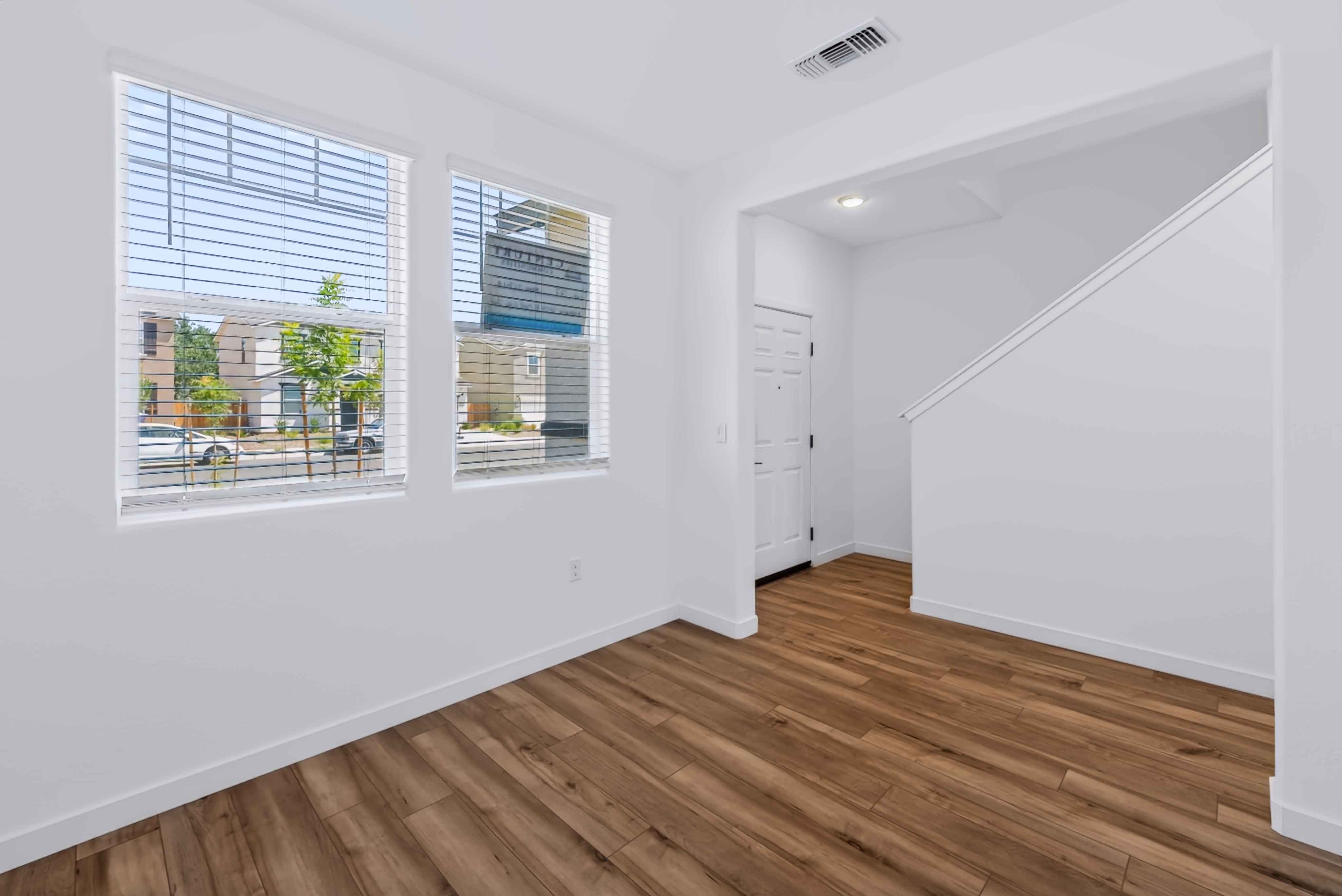 A room with a wood floor and a wood floor with a window.