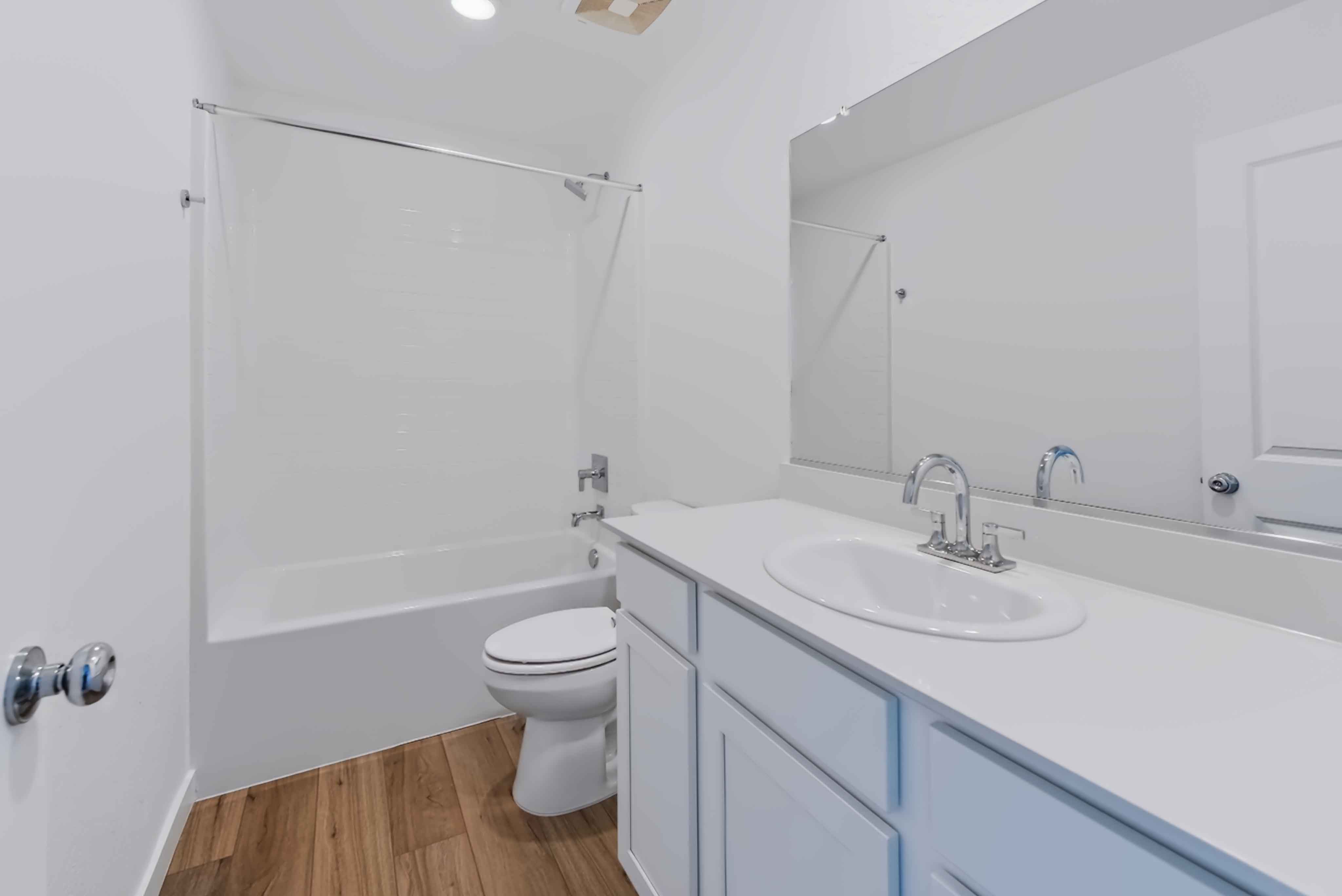 A bathroom with a sink toilet and shower.