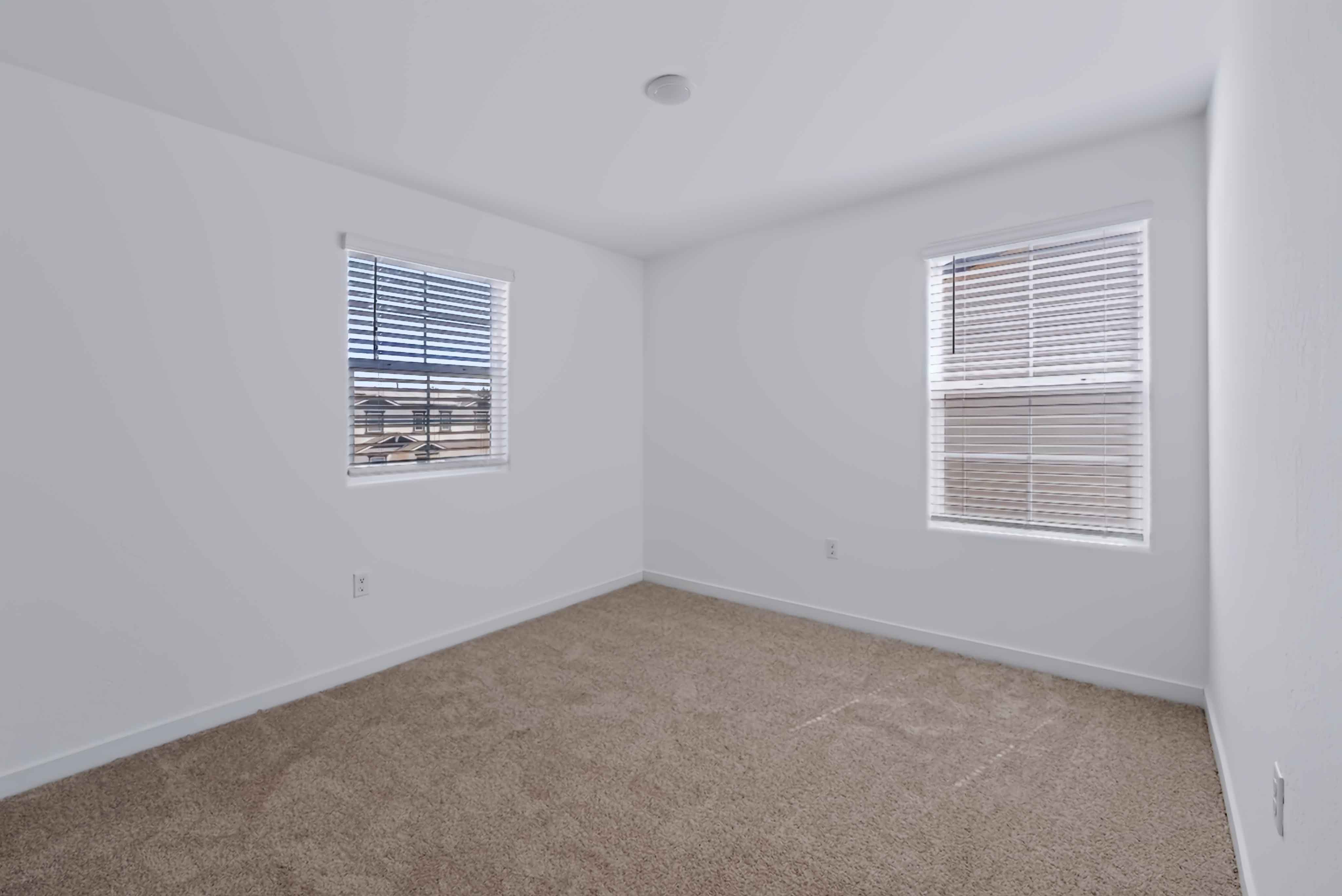 A room with a carpet and a window.