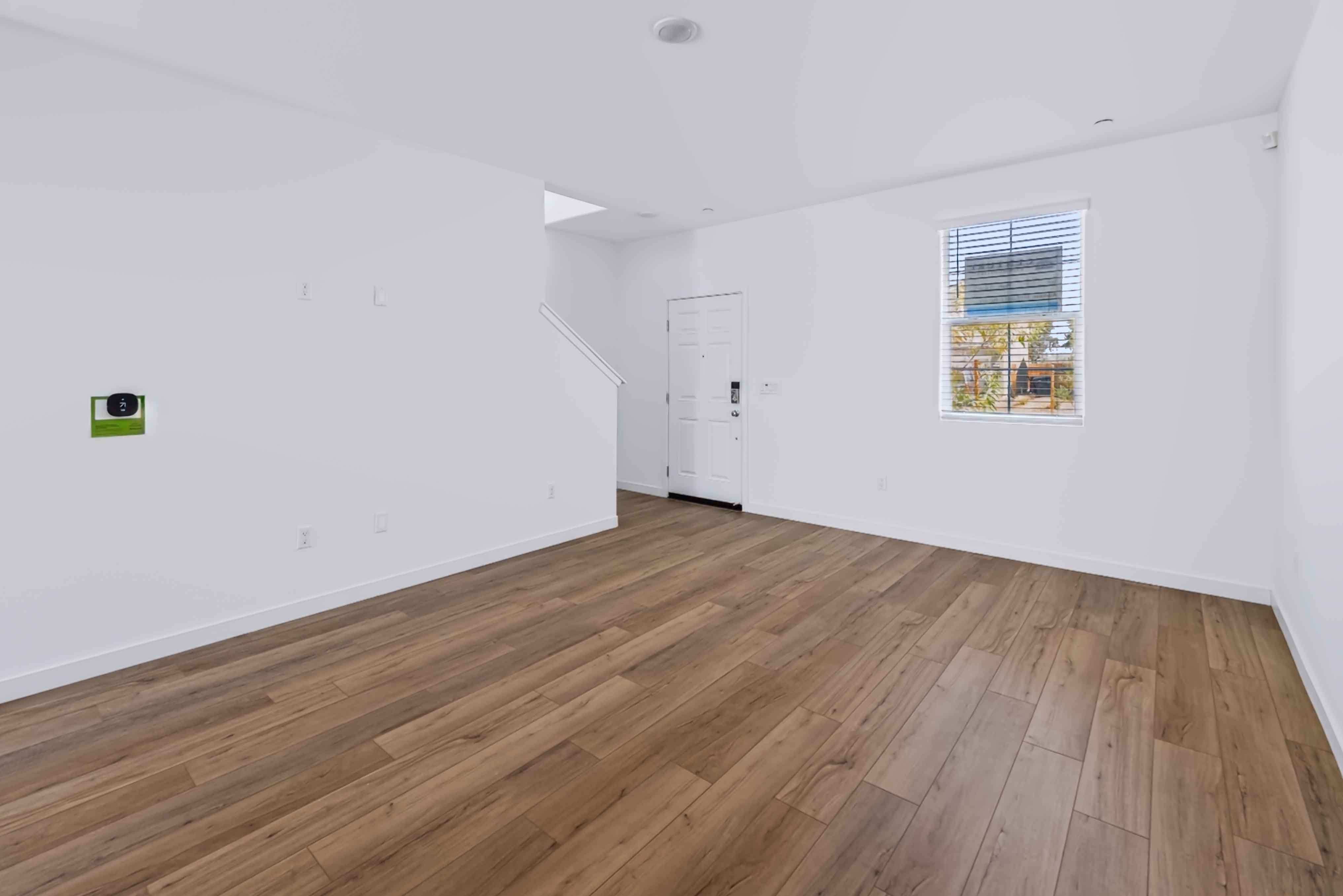 A room with a wood floor and white walls.