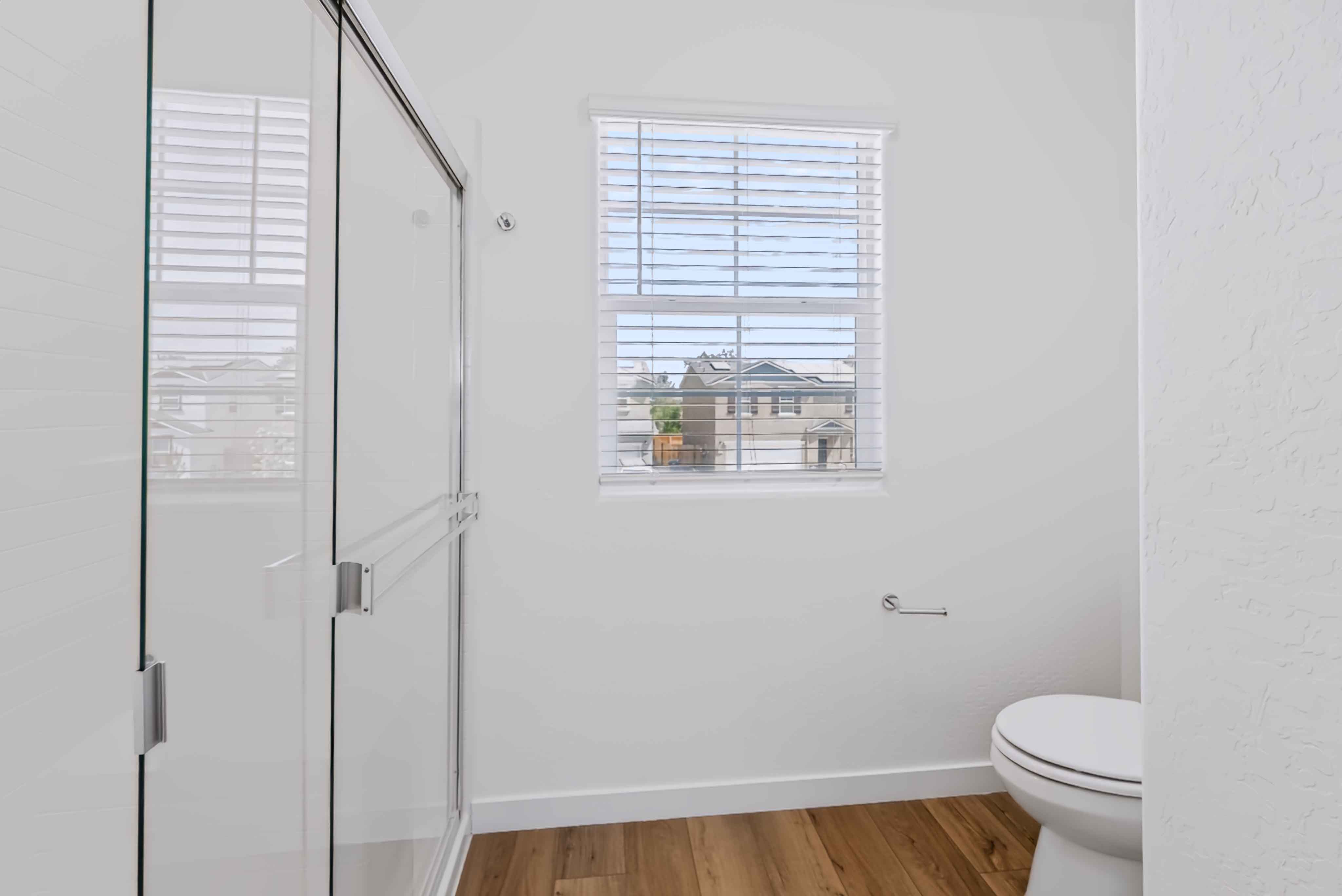 A bathroom with a toilet and a window.