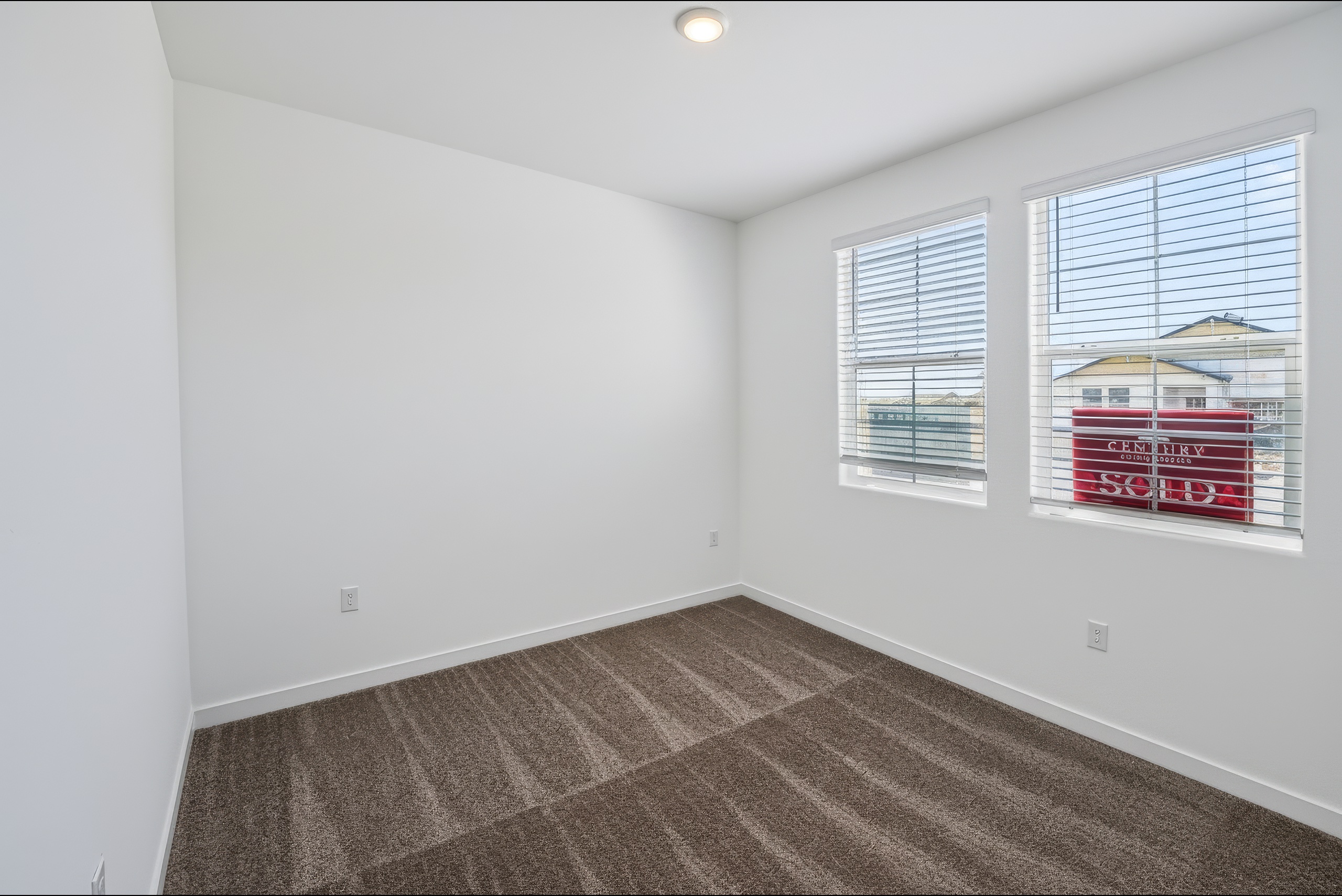 A room with a window and a rug in it.