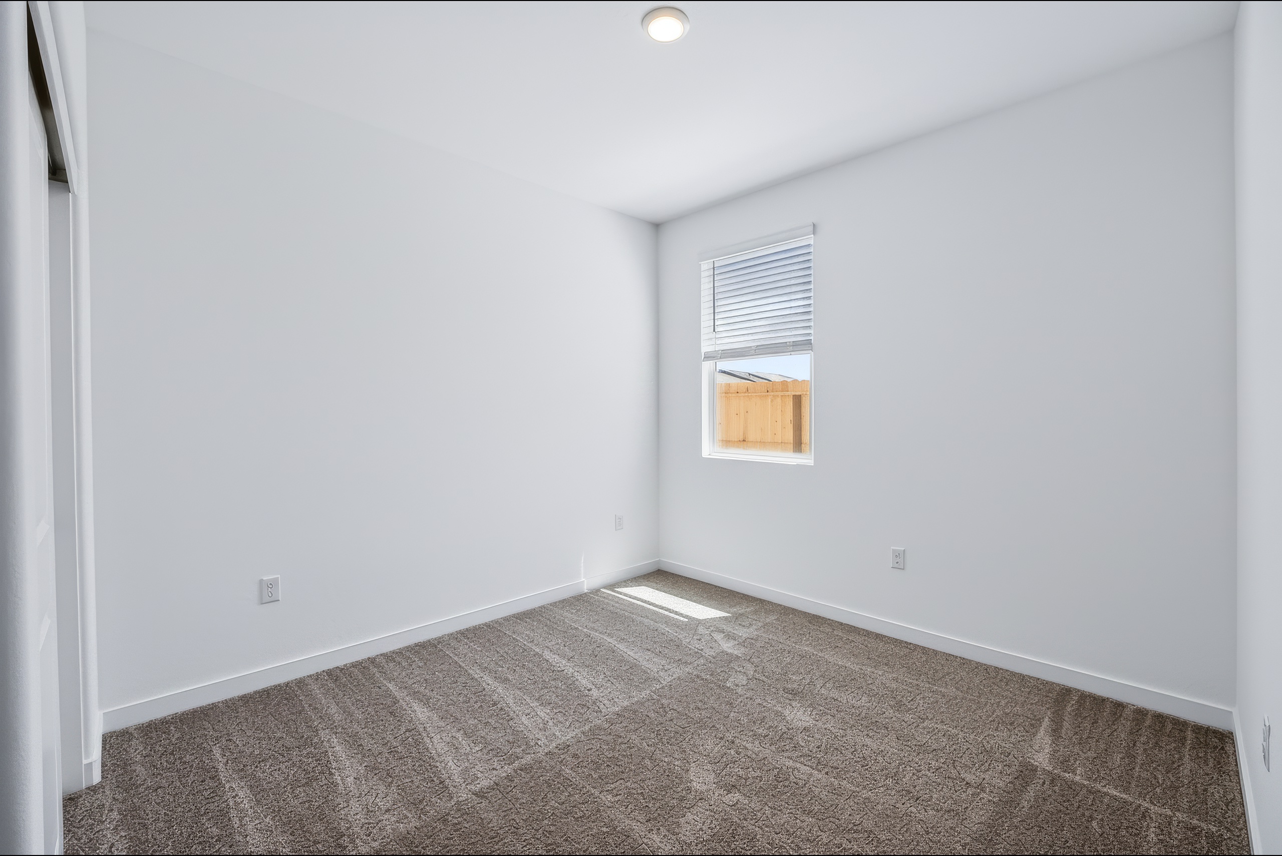 A room with a carpet and a window.