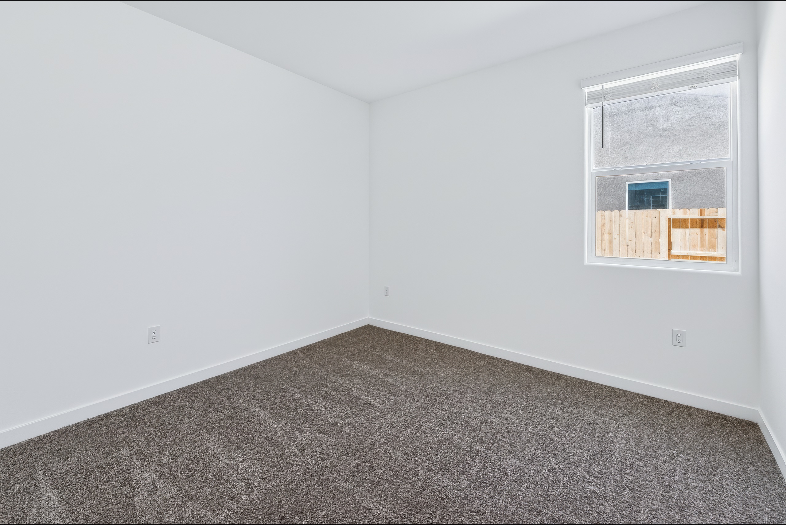 A room with a carpet and a window.